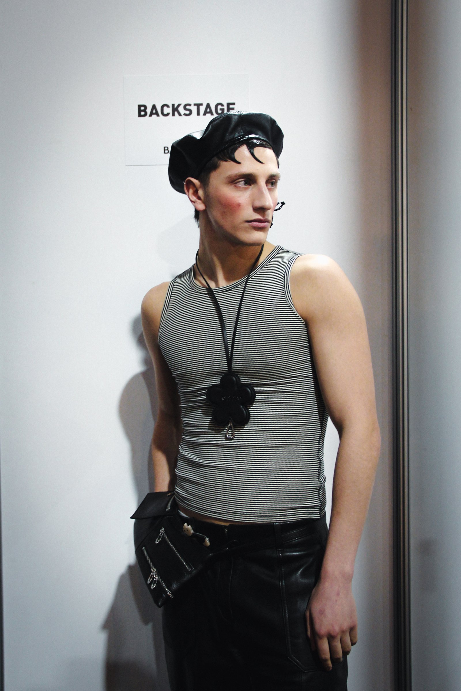 Modelo con musculosa gris en el backstage