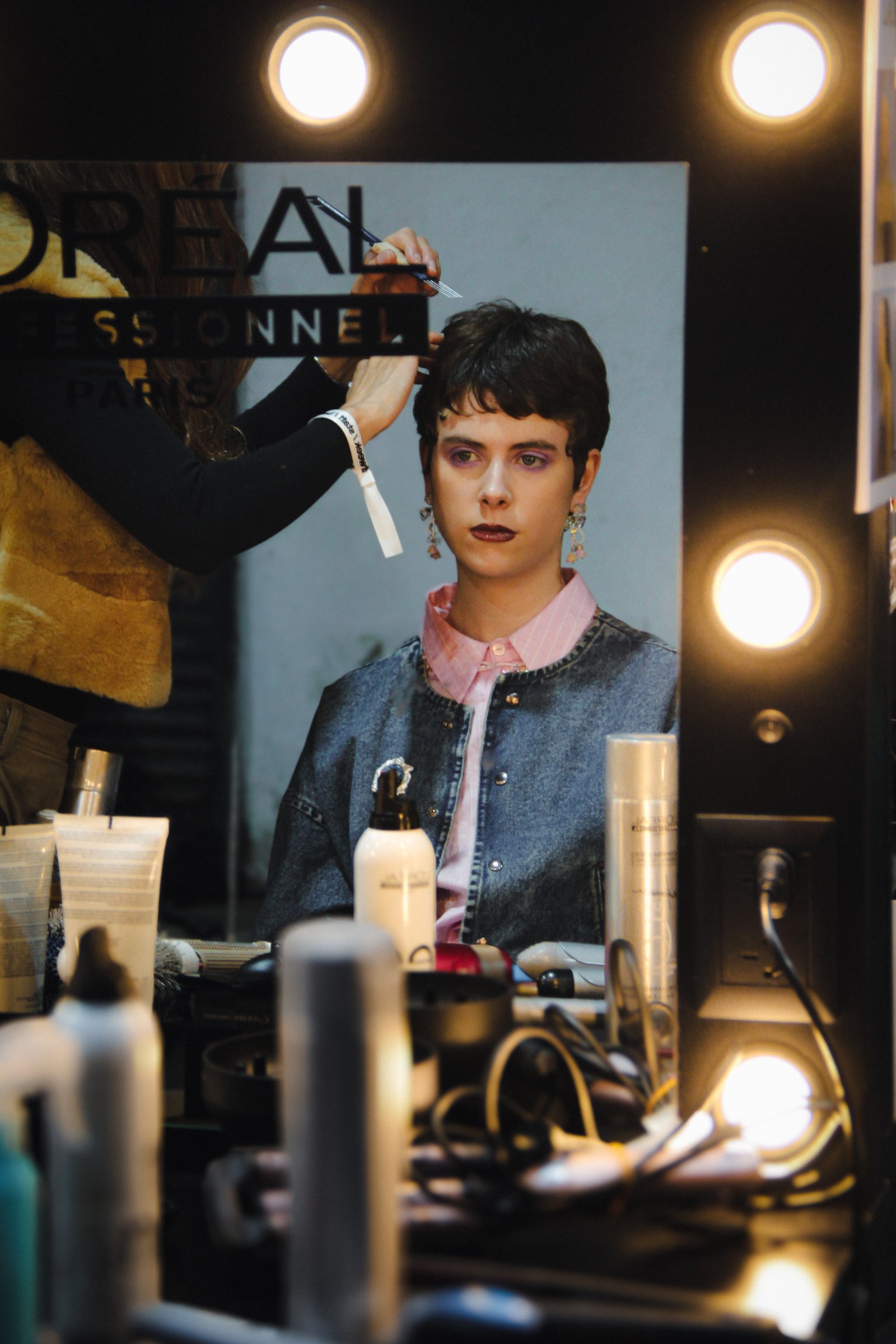 Backstage de moda frente al espejo de maquillaje
